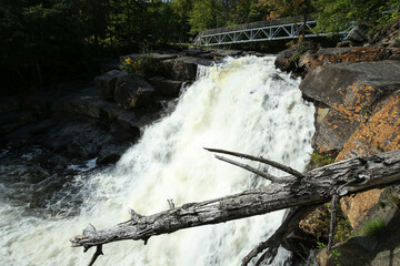 Chute Marcotte sur la rivière Noire avec rocher et tronc d'arbre.Parc régional Portneuf. Waterfall and bridge and rocks Portneuf regional park, Quebec Canada