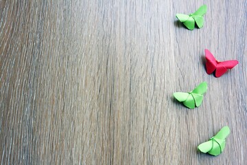 Colorful paper butterfly on a wooden board