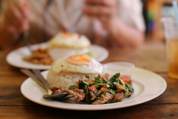 Thai food : Pad Kaphrao is Stirred and fried meats with holy basil and chilies served on steamed rice and fried egg. Shooting in studio for advertising. Thai and Asian food.