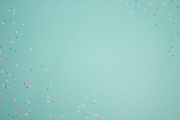Colorful confetti over the mint background with copy space.