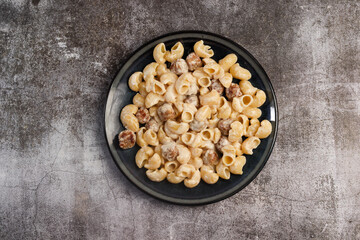 Creamy Pasta with Meatballs on a round plate on a dark grey background. Top view, flat lay