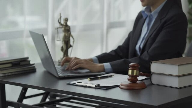 Female lawyer working with hammers and scales The goddess of injustice with the concept of online legal counseling laptops. 4k