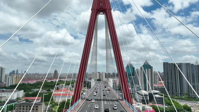 Flying over to great bridge in the city. Drone aerial view. Cars traffic in the highway on bridge over the river, city skyline in background.  Transportation cityscape business concept b-roll footage.