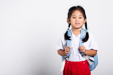 Asian adorable toddler smiling happy wearing student thai uniform red skirt standing in studio shot...