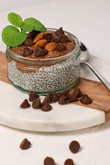 chia pudding with chocolate and almonds on white table