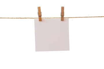 Empty color paper sheets for notes, frames that hang on a rope with clothespins and isolated on white.