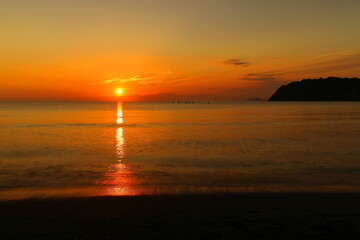 秋の逗子海岸、オレンジ色に染まる水面と空