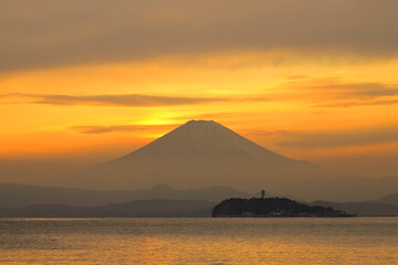 Naklejka na ściany i meble 夕焼けに染まる空に浮かび上がる富士山と江ノ島のシルエット