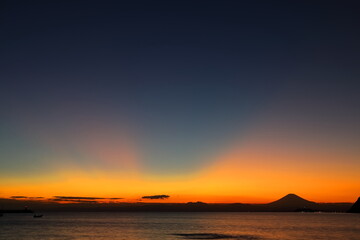 日没後にオレンジ色に染まる空と富士山のシルエット