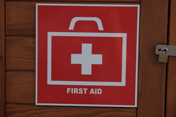 "First Aid" sign on the background of a wooden box with a lock