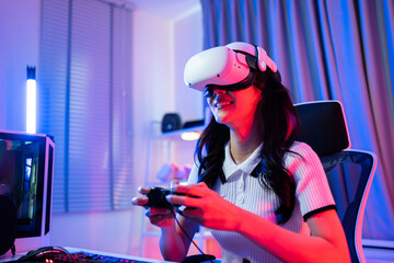 Asian young Esport woman gamer use technology VR glasses and play game.  © Kawee