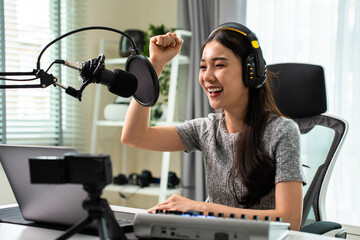 Asian attractive audio DJ woman speaks into microphone to broadcasting
