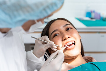 Orthodontist doctor examine tooth to woman patient at dental clinic. 