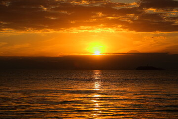 秋の逗子海岸の夕暮れ、夕焼けに染まる海と日没直前の夕陽