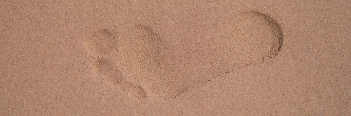 Footprints on wet sand sand on beach closeup