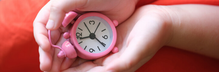 Pink clock compass in children hands closeup