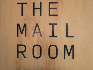 Mail room sign board on the wood background at condominium