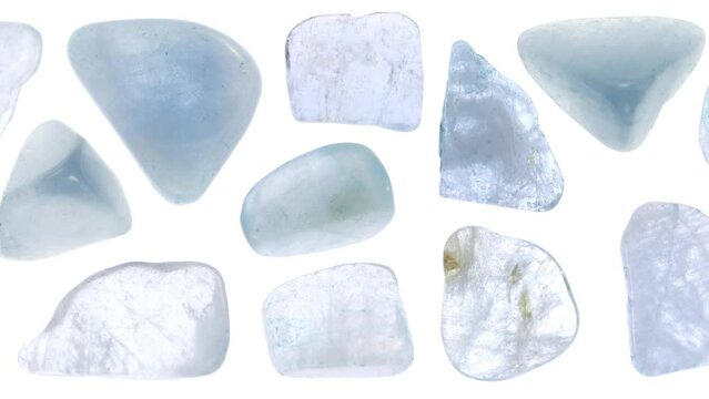 Aquamarine jewel stones set texture on light white isolated background. Macro closeup. Moving right seamless loop backdrop.