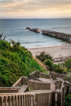 Aerial view of wooden staircases going dawn in background of dock in sea during sunset