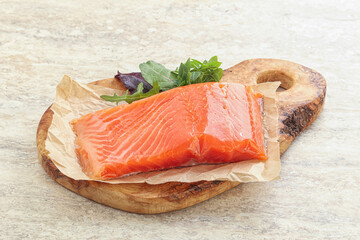 Raw salmon fillet over board