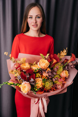 Woman holding orange Autumn Colorful fall bouquet. blooming flowers festive background, autumn orange and red flowers. bouquet floral card. Mothers day, International Women's Day.