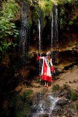 a girl in Chuvash national dress and the waterfall "Silver Cascade" in the Morgaus district of Chuvashia