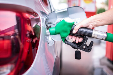 Woman's hand filling fuel into the car tank at the pump service station, for concept transportation...