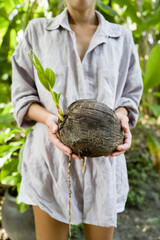 Woman holding sprouted coconut