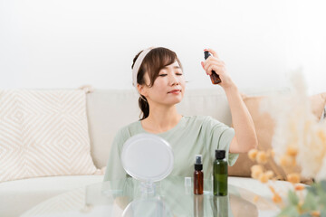 自宅でスキンケアするアジア人女性（スプレー・ミスト）
