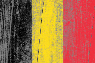 Naklejka premium Belgium flag painted on a damaged old wooden background