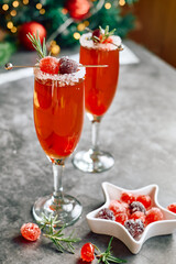 Christmas mimosa punch or cranberry margarita cocktail with cranberry juice, orange liqueur and champagne. Delicious icy drink for christmas holiday.