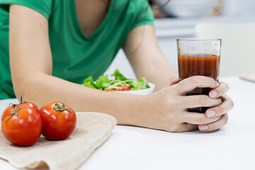 Low calories drink for wellness. woman making homemade drink by extracting fresh tomato juice.