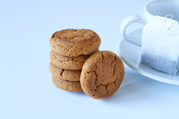 Oatmeal cookies with a white cup and saucer on a white background. Concept - morning tea, delicious breakfast.