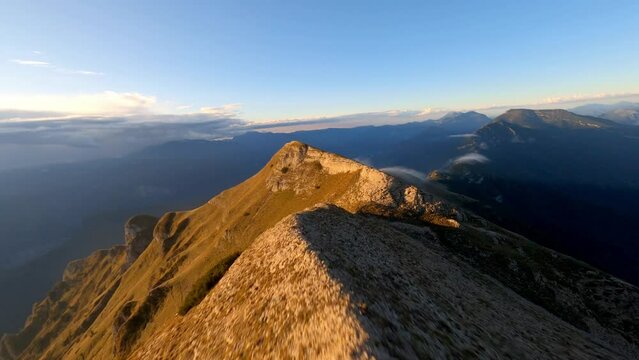 Spectacular fpv dynamic shot on mountaintop of Monte Bondone during golden sunset,Italy 