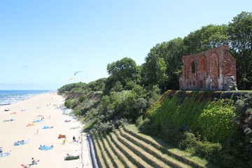 Castle ruins by the sea. Beach in summer.