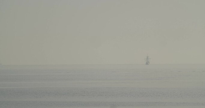 Ferdinand Magellan Nao Victoria carrack boat replica sails in the distance in the mediterranean at sunrise in calm sea in slow motion 60fps