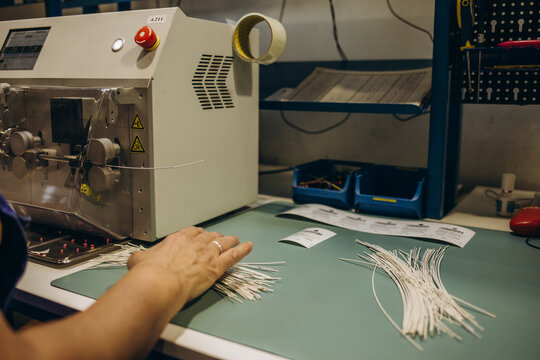 close-up of hands working on industrial machine for cutting cable