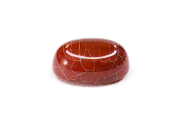 Shiny brick red dragon white vein agate polished cabochon crystal stone isolated on a white surface background macro shot