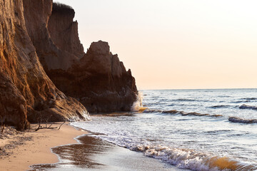 Clay cliffs on the seashore at dawn. Precipice coast near the sea