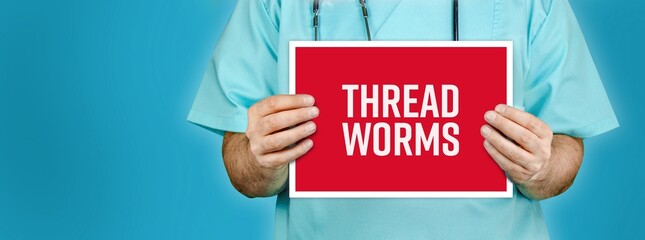 Threadworms (pinworms). Doctor shows red sign with medical word on it. Blue background.
