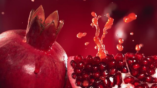 Slow Motion Shot of Pomegranate Juice Splashing through Pomegranate Slices