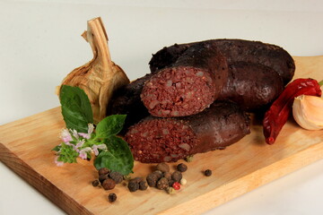 Baked blood sausage. Buckwheat sausage. Blood bloody sausages on wooden cutting board. Homemade...