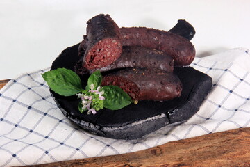 Baked blood sausage. Buckwheat sausage. Blood bloody sausages on wooden cutting board. Homemade...