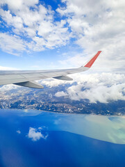 Fototapeta premium Airplane flying above the clouds - aircraft wing in the blue sky