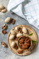 Nuts and seeds, healthy fats, various trace elements and vitamins. Bowl with pecan nuts on a stone table. View from above.