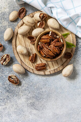 Bowl with pecan nuts on a stone table. Nuts and seeds, healthy fats, various trace elements and vitamins. View from above. Copy space.