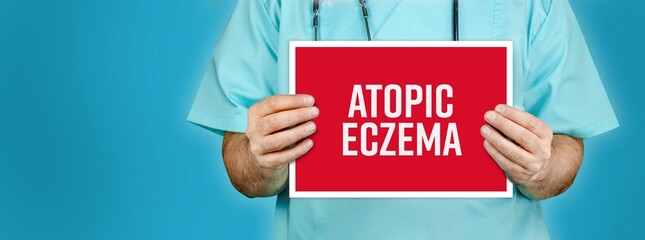 Atopic eczema (atopic dermatitis). Doctor shows red sign with medical word on it. Blue background.