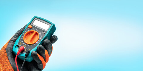 Electrician engineer work tester. Male hand in protective glove holds digital tester. Banner with...