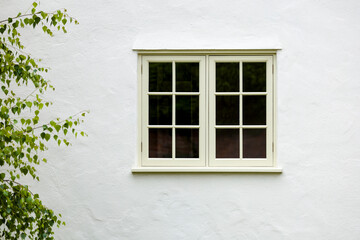 Fototapeta na wymiar House exterior with wooden window and white wall rendering, UK