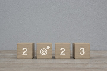 2023 letter with goal icon on wood block cubes on wooden table over white wall background, Happy new year 2023 success concept